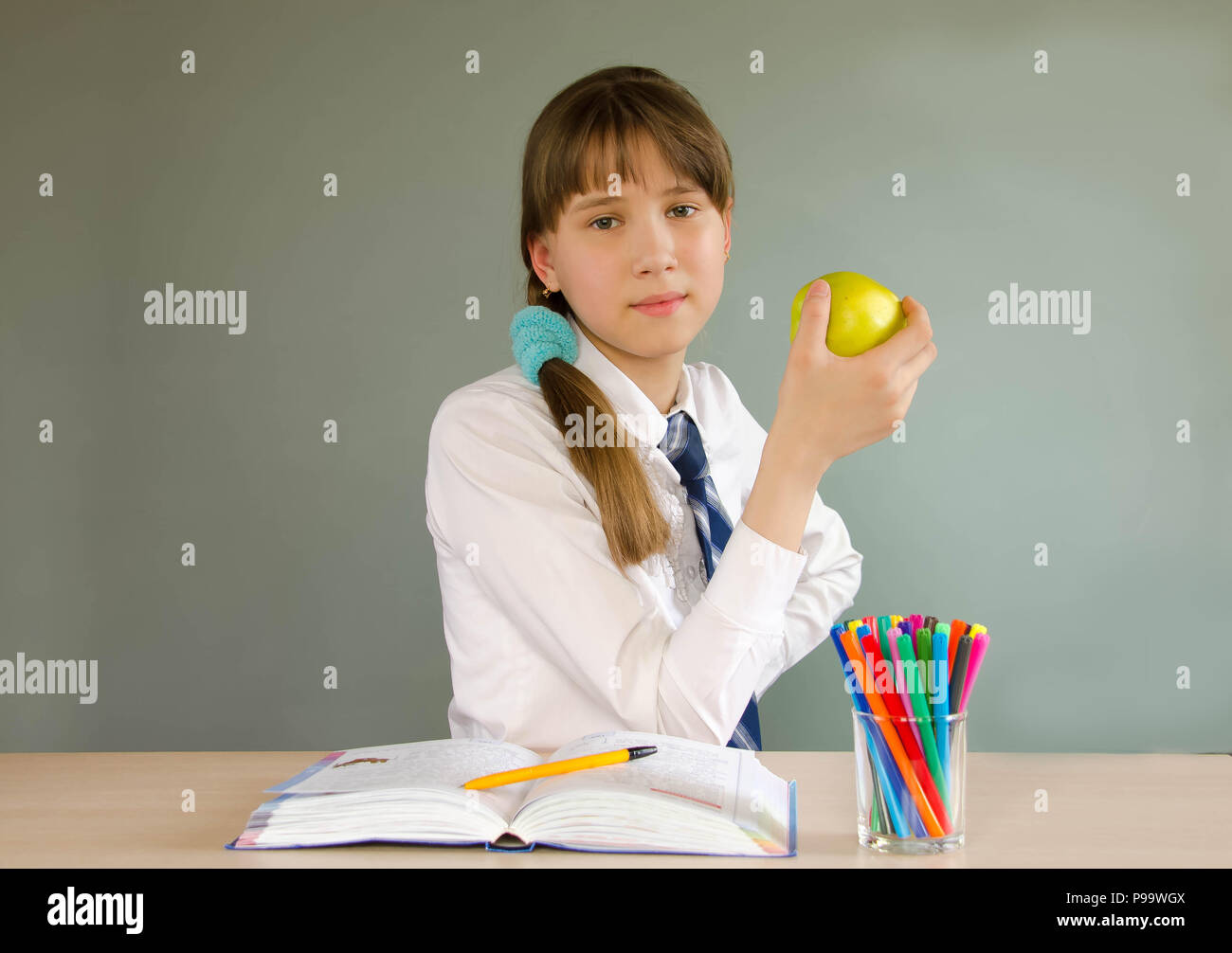 A schoolgirl girl sits at a school desk Stock Photo - Alamy