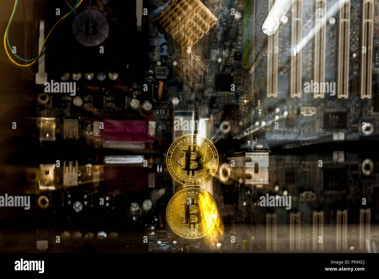Golden bitcoin in front of a  motherboard dynamically zoomed into the bitcoin concept for crypto currency Stock Photo