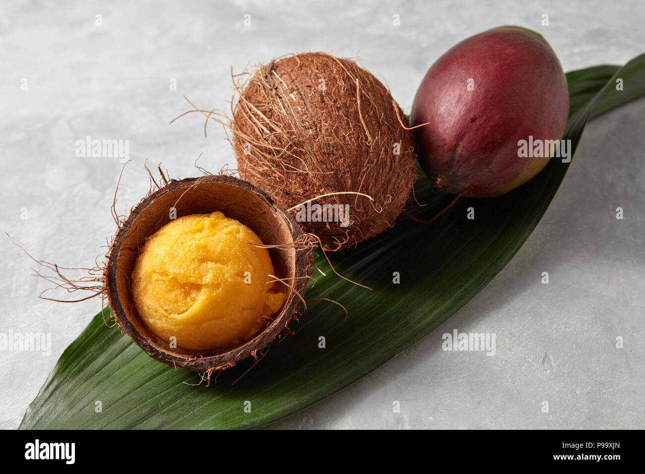 https://c8.alamy.com/comp/P99XJN/organic-whole-coconut-whole-mango-and-a-mango-ice-cream-ball-in-coconut-shell-on-a-gray-concrete-background-with-copy-space-top-view-P99XJN.jpg