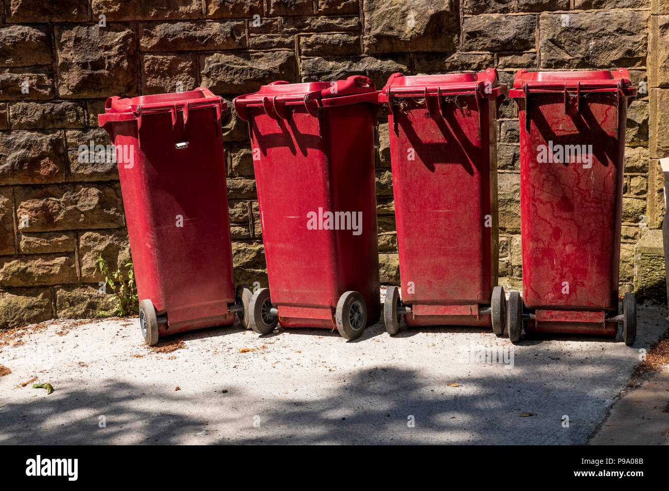 Four burgundy recycling bins in the sunshine Stock Photo Alamy