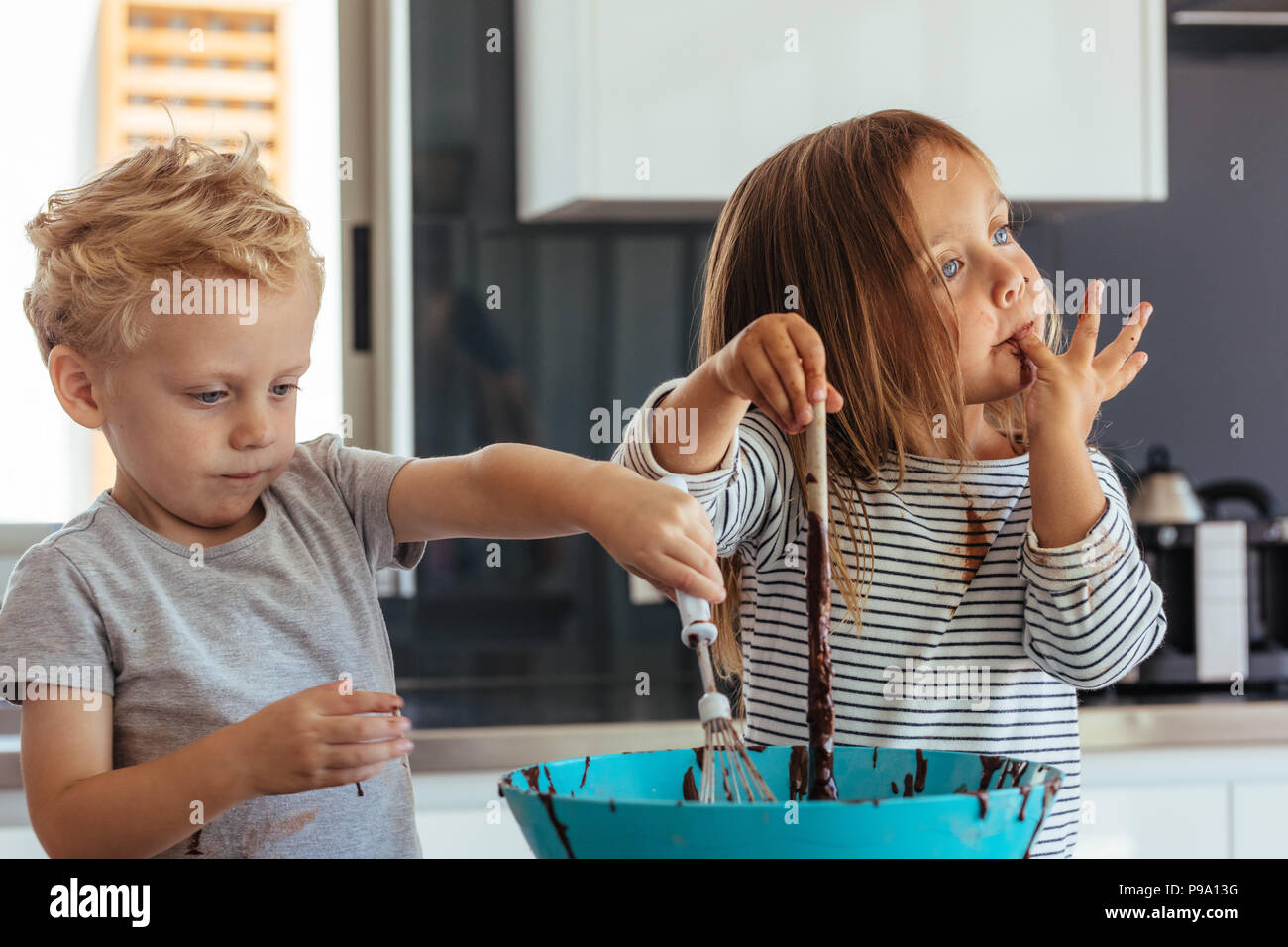 Little Boy And Girl Mixing Batter In A Bowl For Baking With Girl Licking Her Fingers Small Kids Baking In The Kitchen Stock Photo Alamy