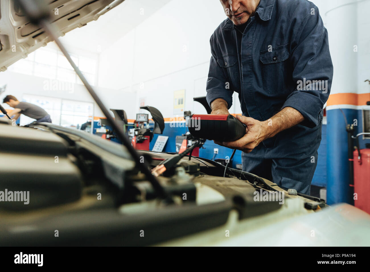 Technician using electronic diagnostic equipment to check the car