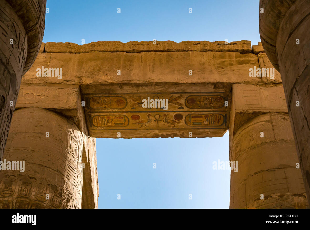 Looking up at colourful painted  Egyptian hieroglyphs at top of columns, great hypostyle hall precinct of Amun Ra, Karnak Temple. Luxor, Egypt, Africa Stock Photo