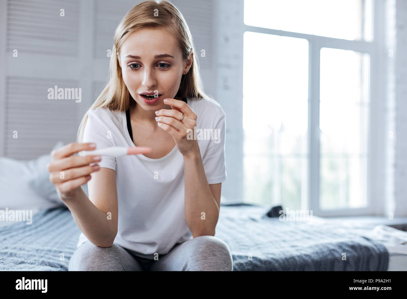 Happy woman holding her pregnancy test Stock Photo