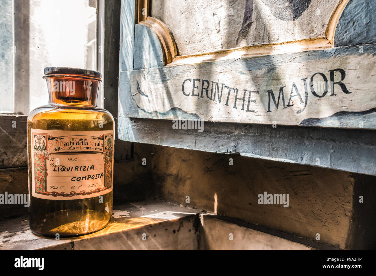 A bottle of licorice composed over a table near the window of the back room of the principale hall of the old Pharmacy and Apothecary 'Farmacia di S. Maria della Scala' in Piazza della Scala in Trastevere quarter, Rome, Italy Stock Photo