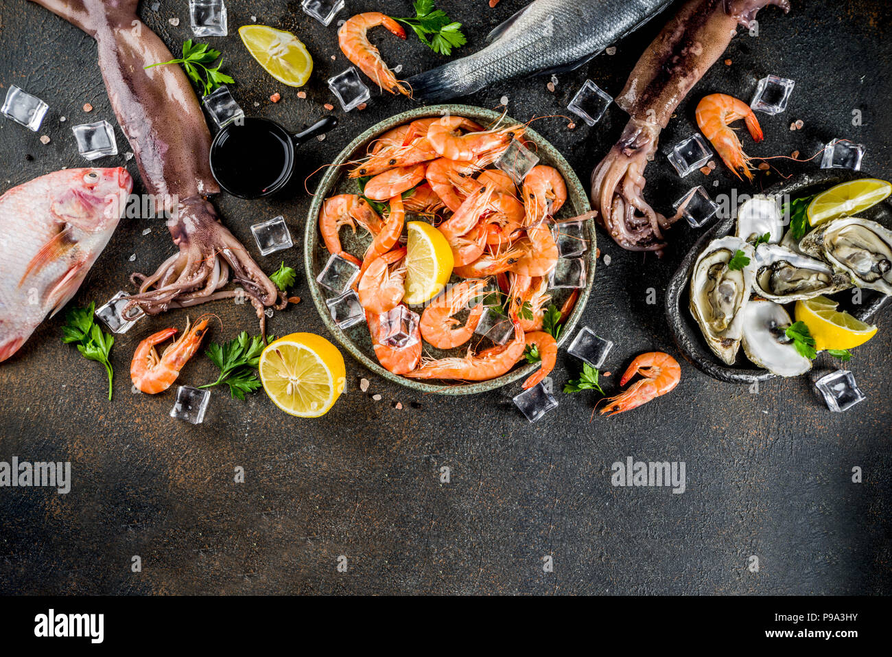 Fresh raw seafood squid shrimp oyster mussels fish with spices of herbs