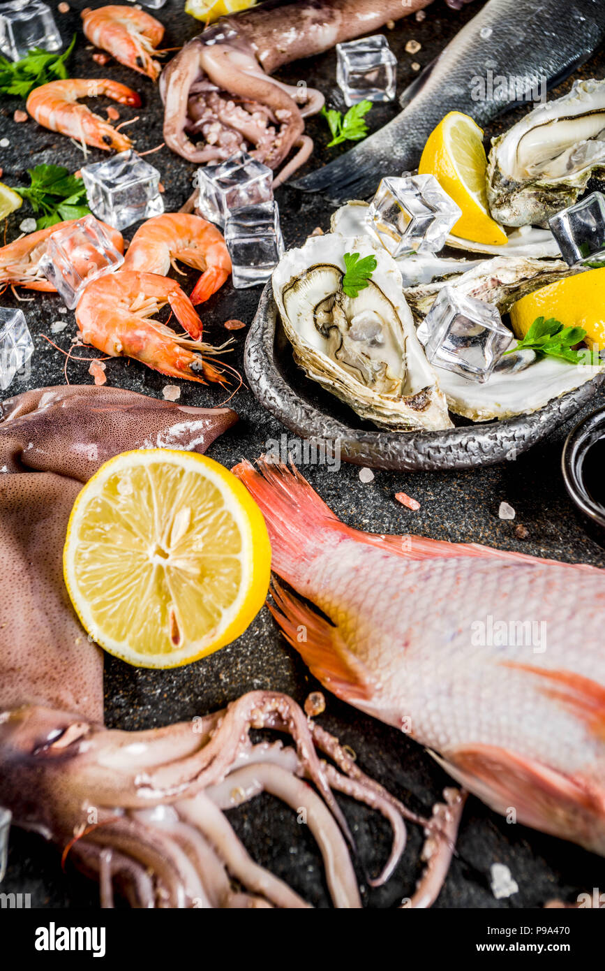 Fresh raw seafood squid shrimp oyster mussels fish with spices of herbs