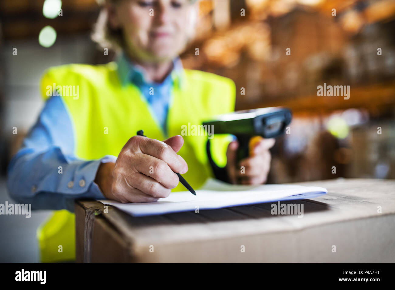 Warehouse woman worker with barcode scanner. Stock Photo