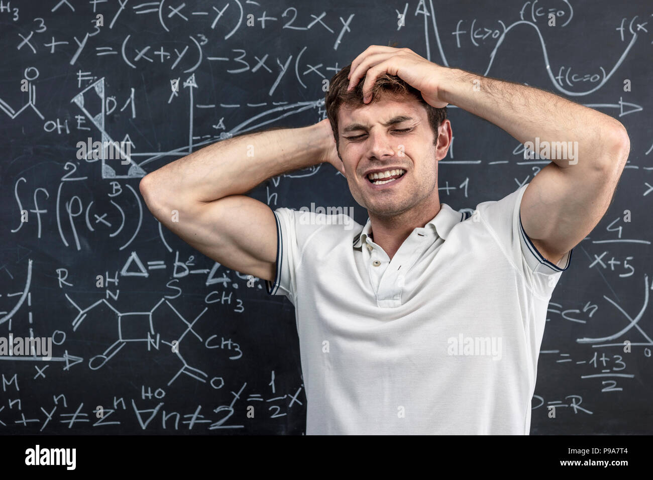 portrait of stressed student and blackboard background Stock Photo