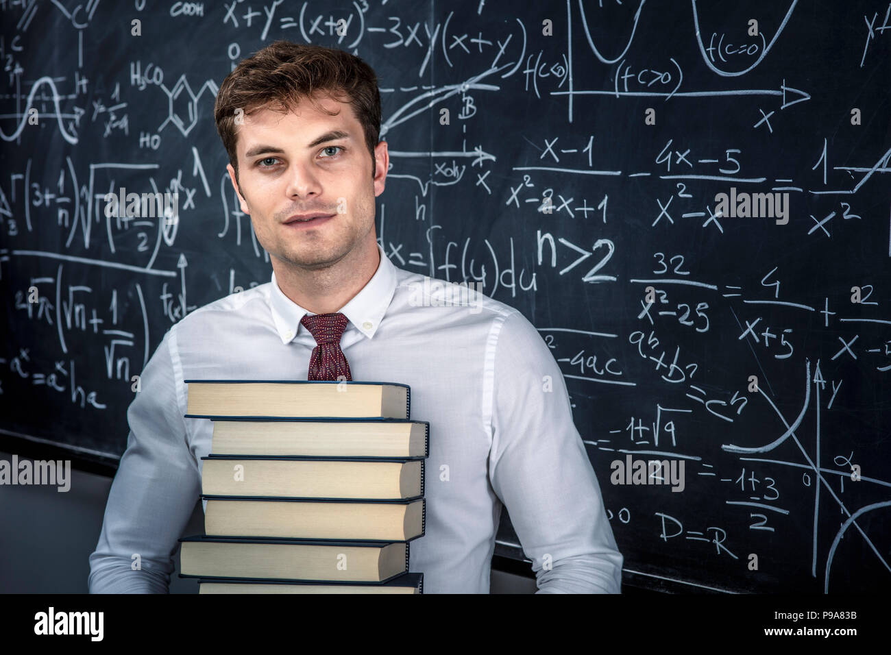 teacher with books and blackboard background Stock Photo Alamy