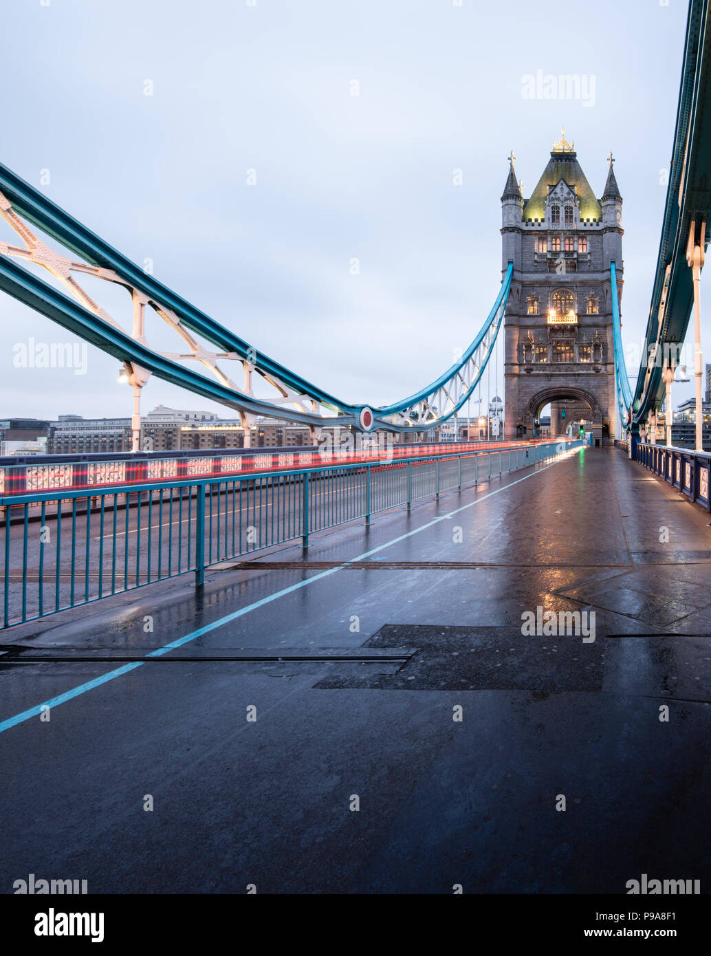 Early morning portrait view of Tower Bridge, London, on a dreary, wet day and with light trails from the passing traffic Stock Photo