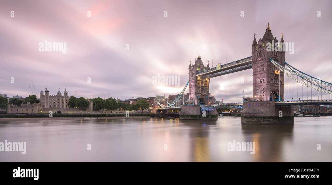 Long exposure image of the Tower of London and Tower Bridge from across the River Thames at sunrise Stock Photo