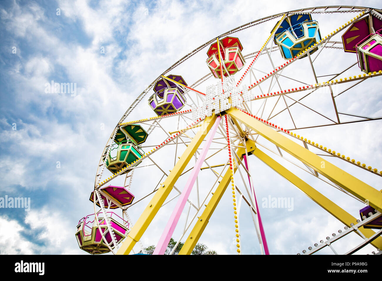 Multicolour ferris wheel on blue sky background Stock Photo - Alamy