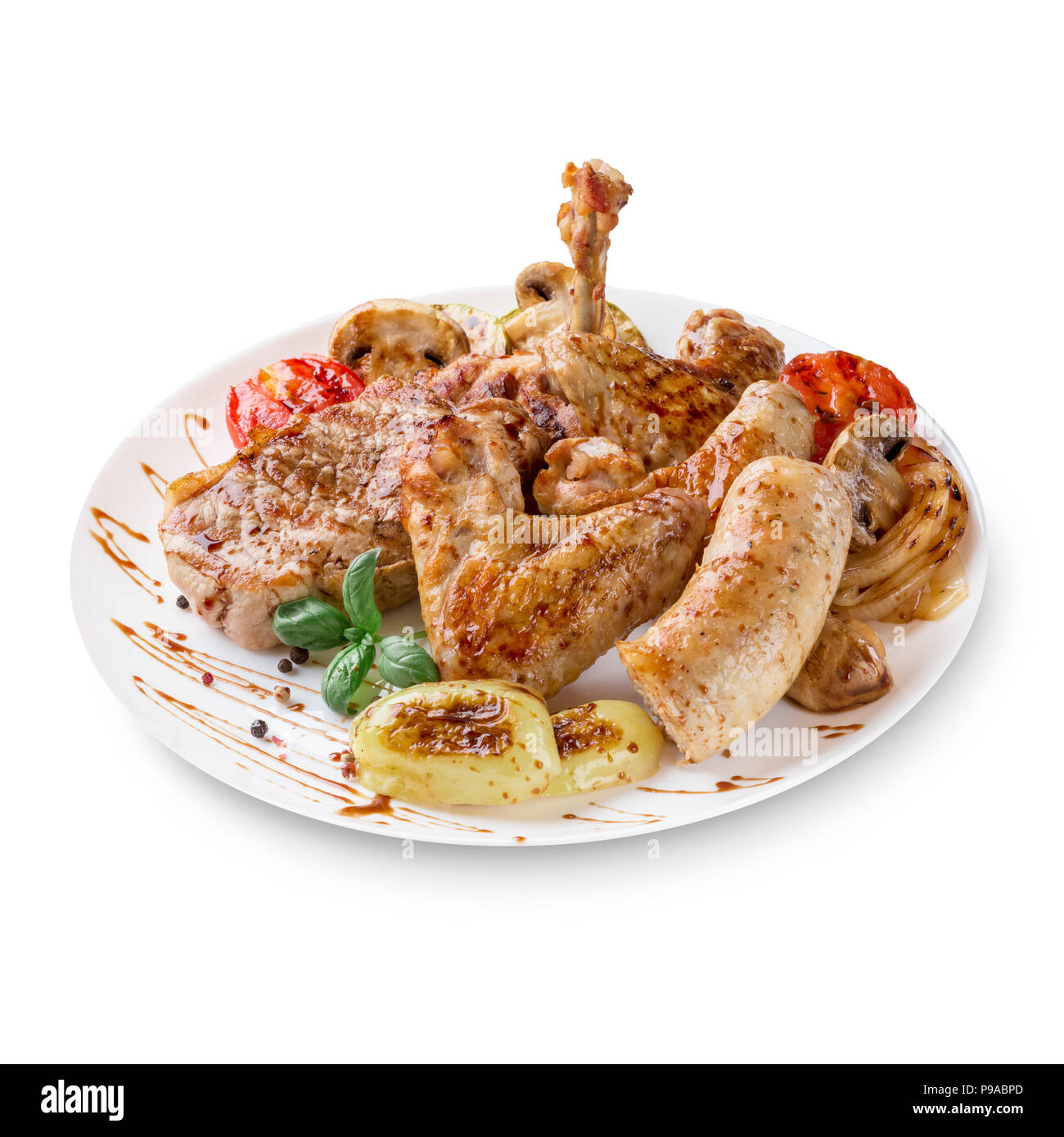 Close-up photo of mixed grilled meat platter. Beef, pork, poultry, sausages, grilled garlic, chili pepper, red tomatoes on white background. Stock Photo