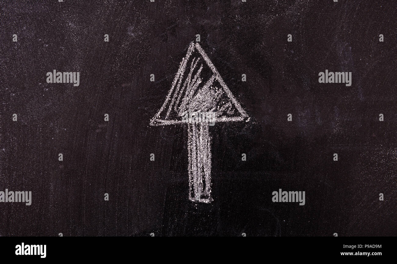 Success concept. Arrow pointing up drawing, isolated, on a blackboard. Stock Photo