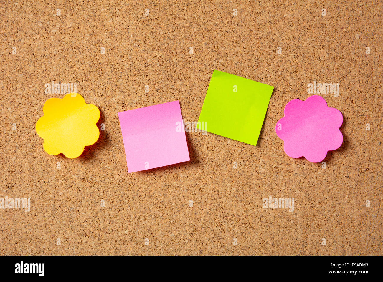 School concept. Four colorful notes in various shapes with copy space on cork background. Stock Photo