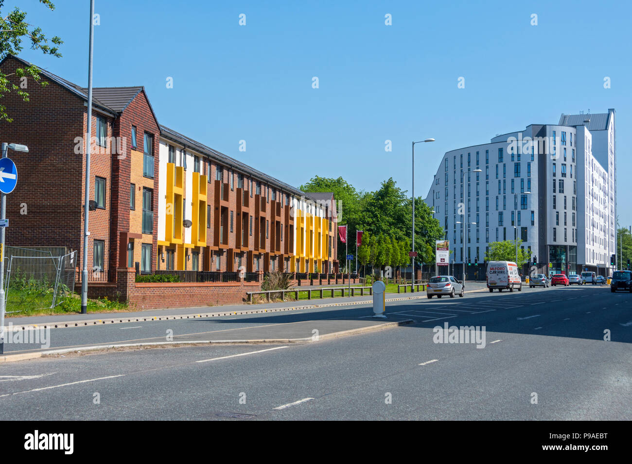 Modern terraced town houses, Brunswick Estate, Upper Brook Street, Manchester, England, UK.  Nick Everton House at right (student accommodation). Stock Photo
