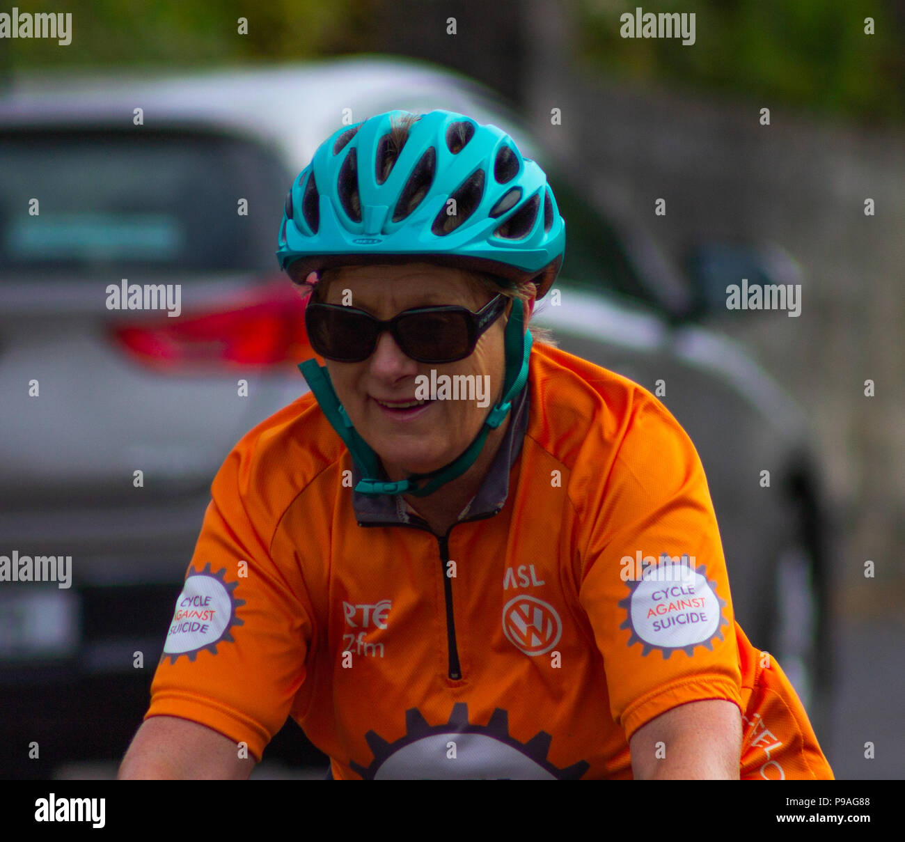 lady cyclist wearing orange sports wear or sportswear. Stock Photo