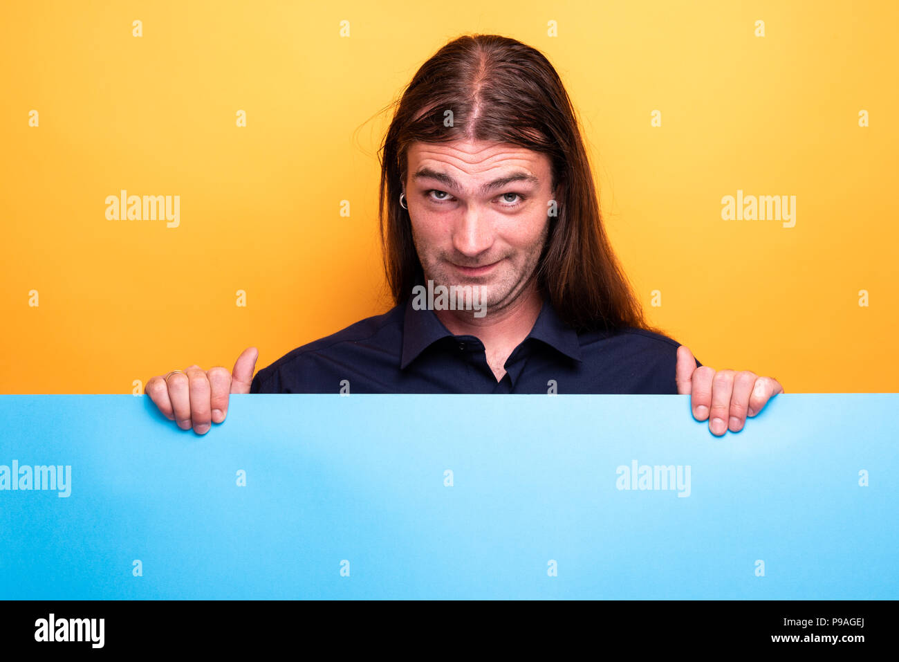 Adult man making grimace while holding cardboard Stock Photo
