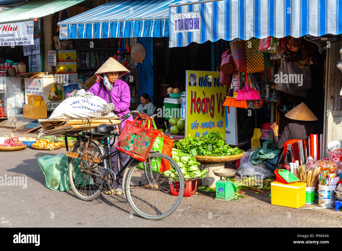 NHA TRANG, VIETNAM - DECEMBER 18: Vietnamese women in the traditional conical hat at the wet market on December 18, 2015 in Nha Trang, Vietnam. Stock Photo
