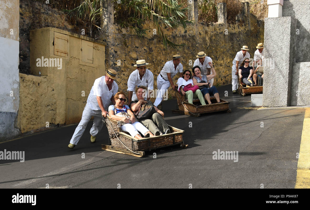 Tourists enjoying a ride downhill on a traditional wicker basket toboggan  on the streets above Funchal, Madeira Island Stock Photo - Alamy
