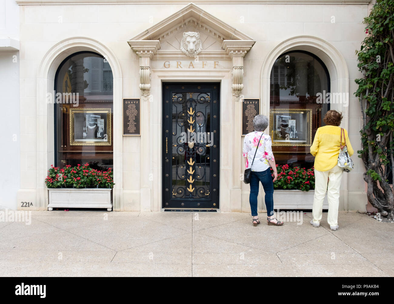 The exterior and entrance to Graff, a high end jewelry store on Worth Ave. in Palm Beach, Fl.. A security man stands in the doorway & two women browse Stock Photo