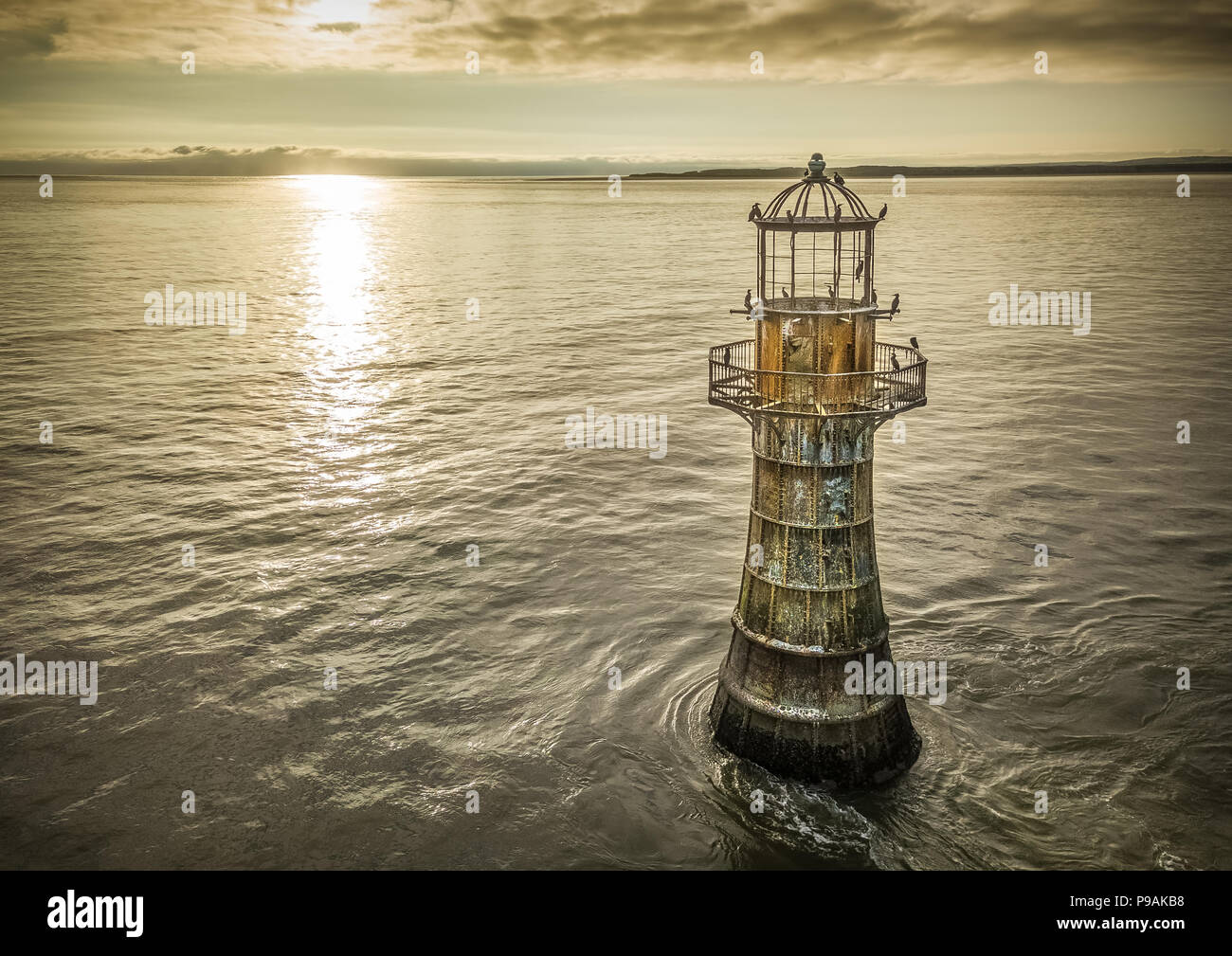 An aerial image of Whiteford Lighthouse at sunset. Now disused apart from it being a great rest stop for the local Cormorants. Stock Photo