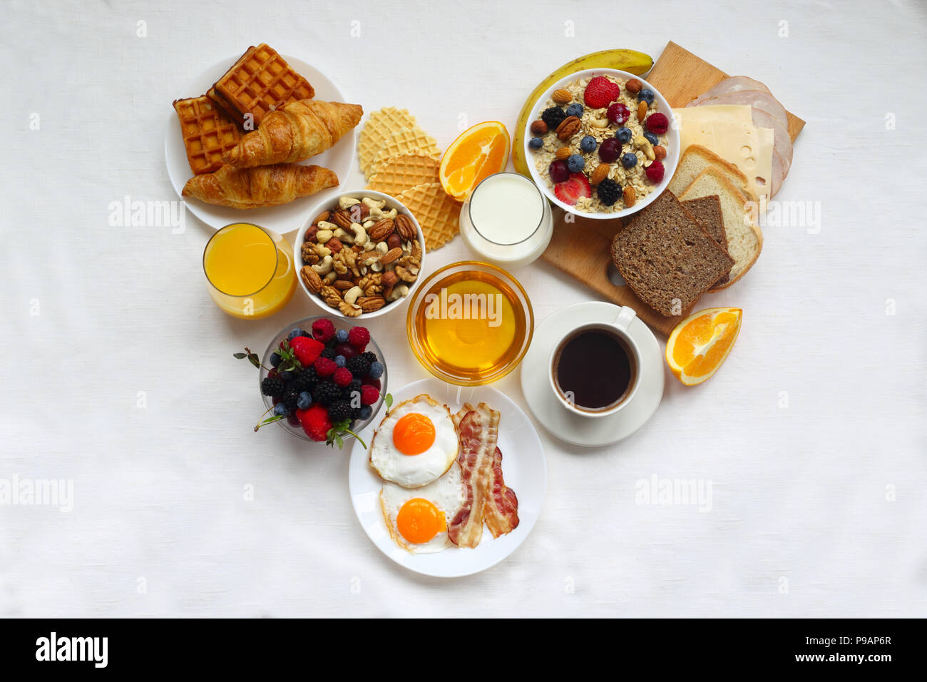 Healthy breakfast with muesli, fruits, berries, nuts, coffee, eggs ...
