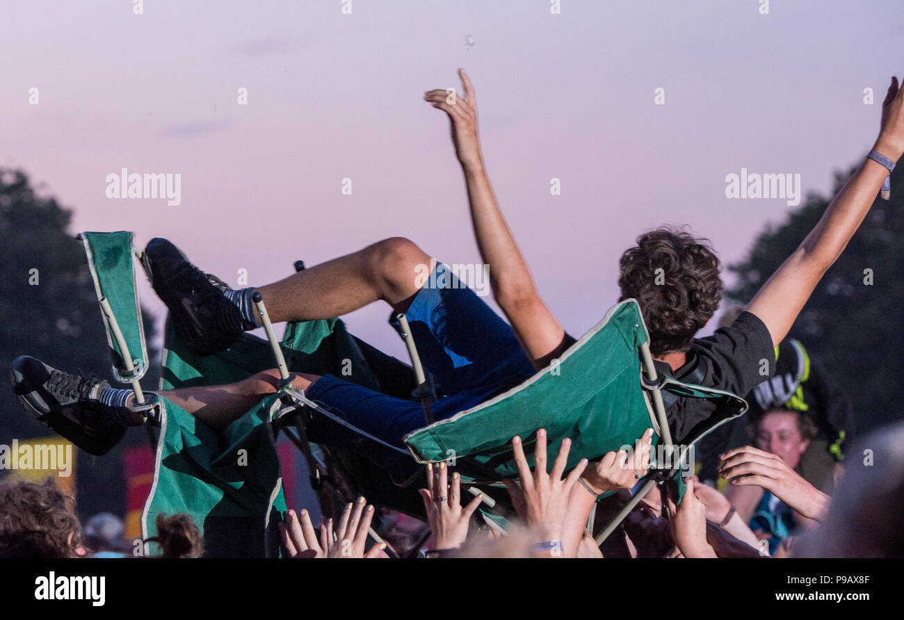 A fan crowd-surfing in his deck chair during Alt-J performance at Latitude Festival, Henham Park, Suffolk, England, 15th July, 2018 Stock Photo