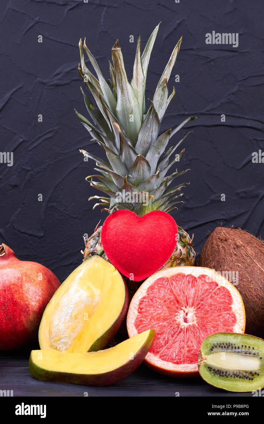 Composition from fresh exotic fruits. Whole and cut tropical fruits on dark background. Fruits