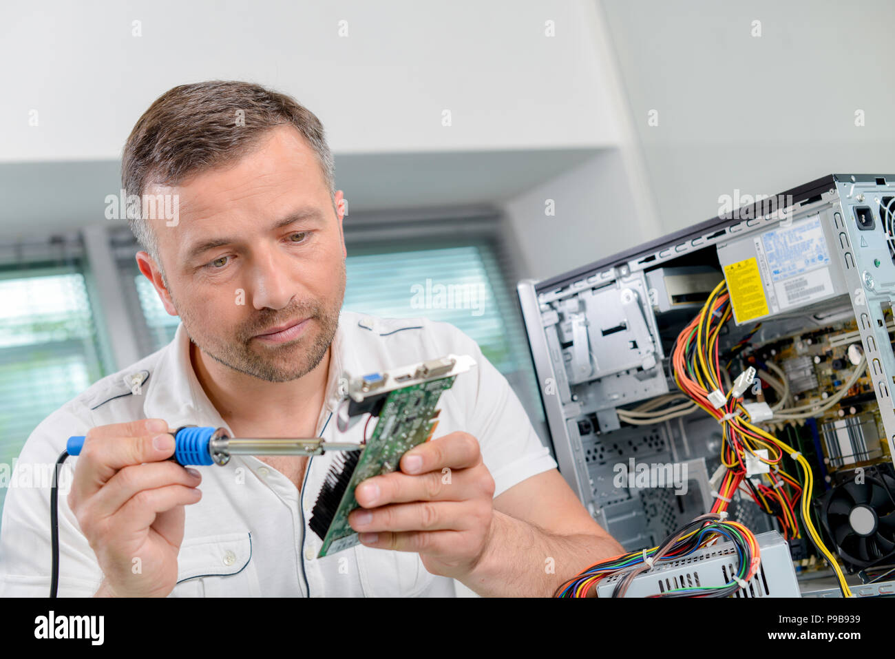 Man soldering computer component Stock Photo Alamy