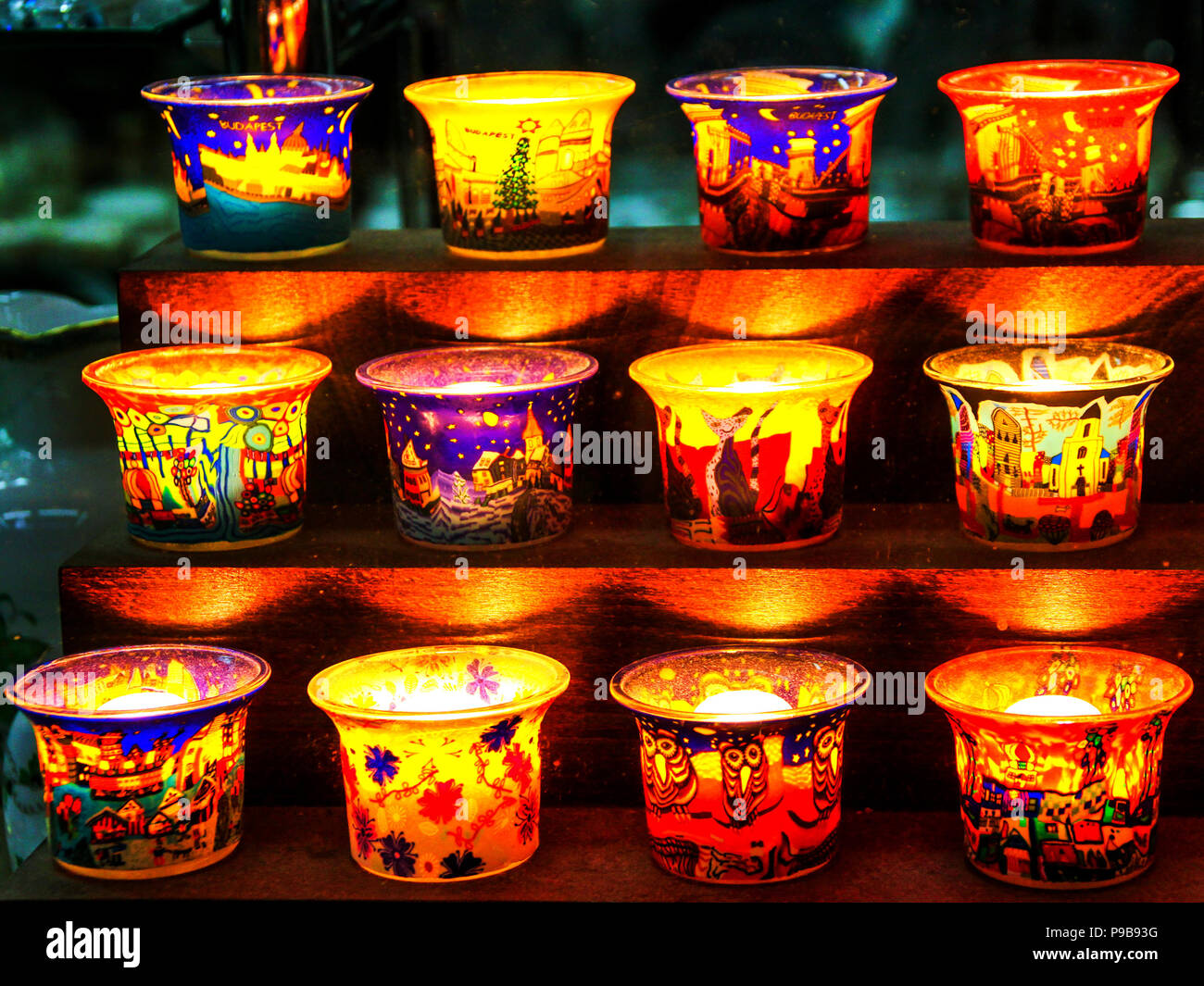 Containers for candles in various colors and painted motifs Stock Photo