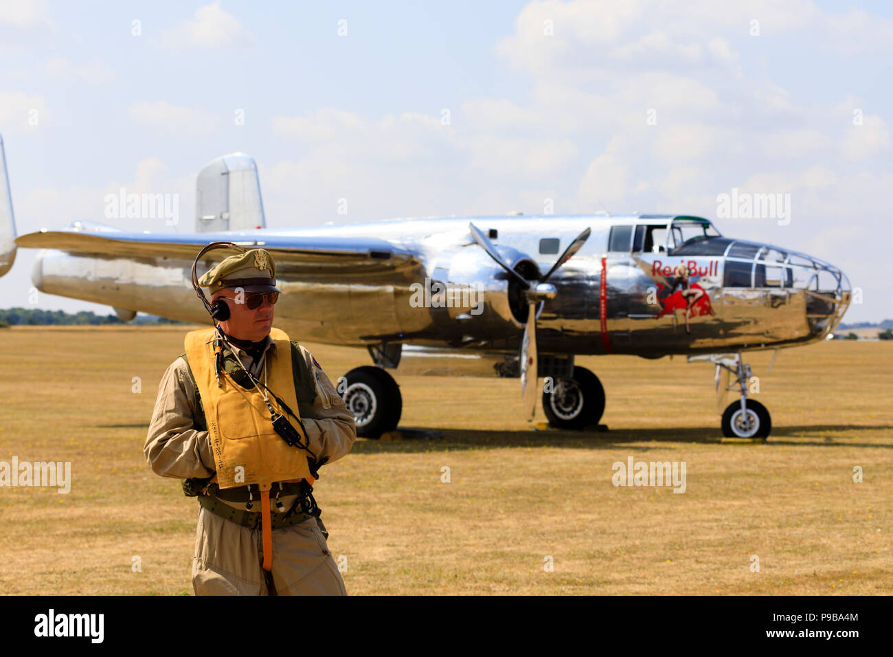 Re-enactor in WW2 flying clothing in front of the Red Bull North American B25J Mitchell medium bomber, N6123C. Stock Photo