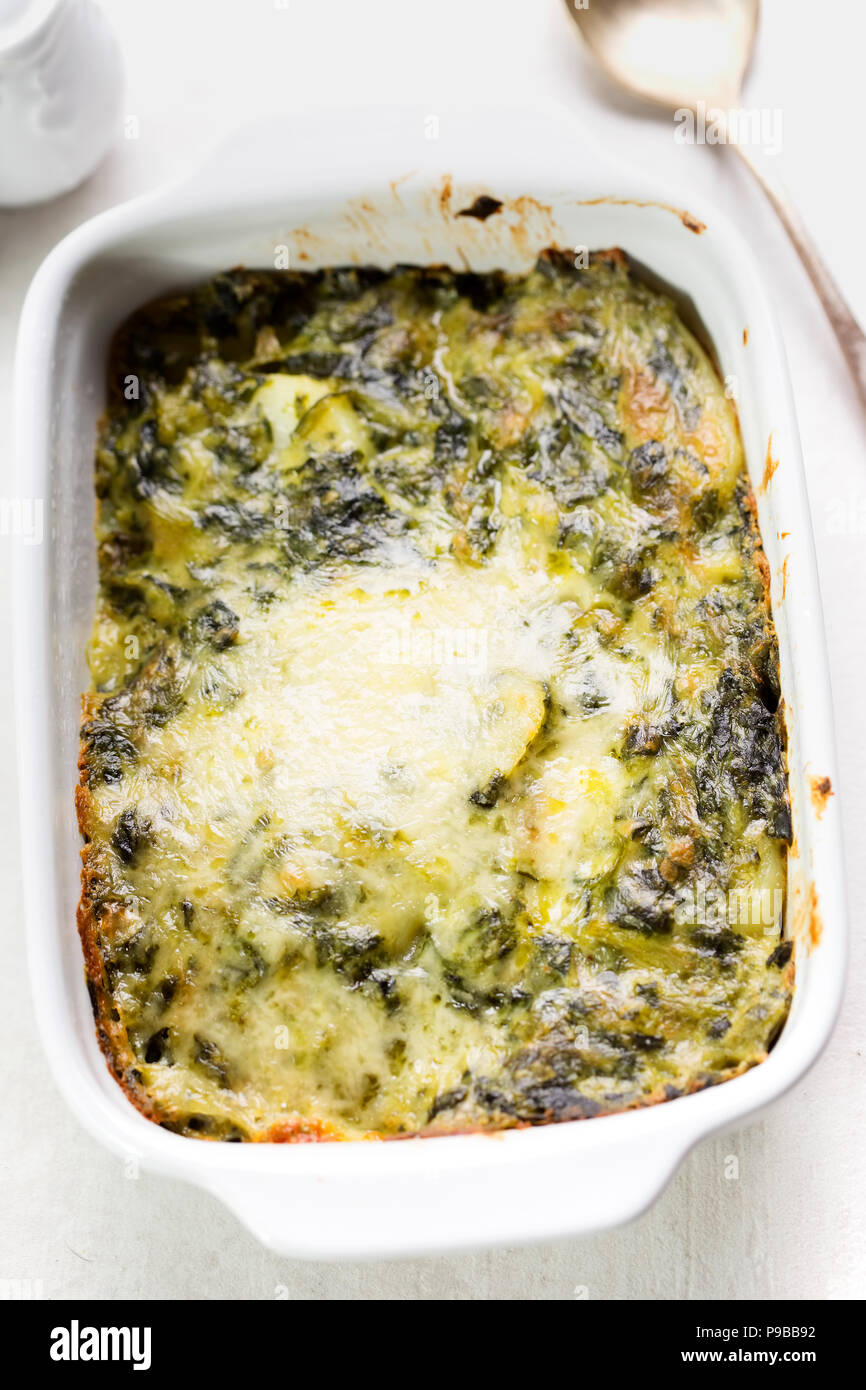 Potato and spinach gratin in creamy garlic sauce Stock Photo