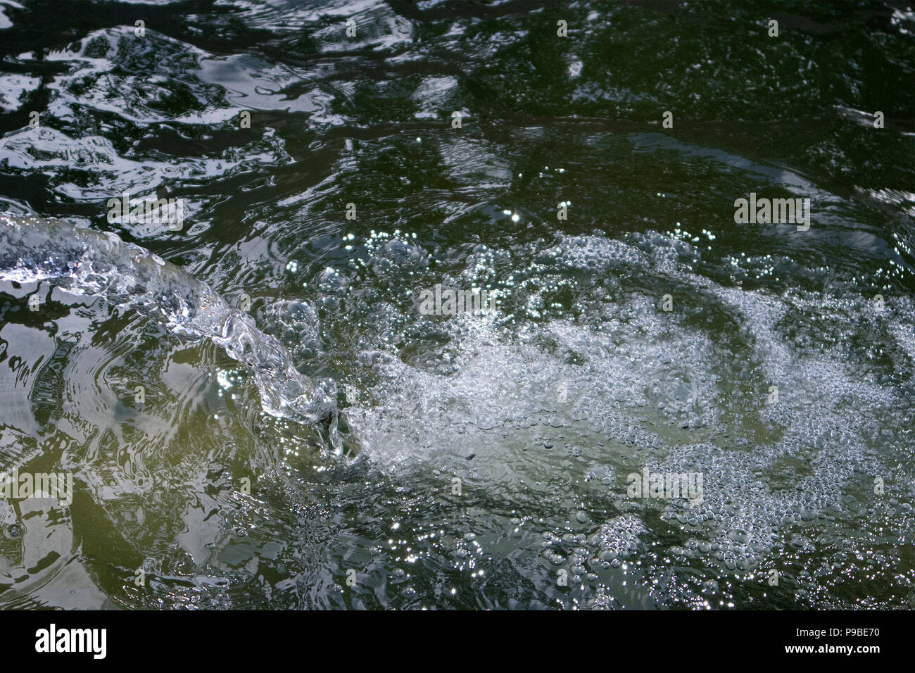 Boiling and foaming bubbled water falling down from the jet in a large