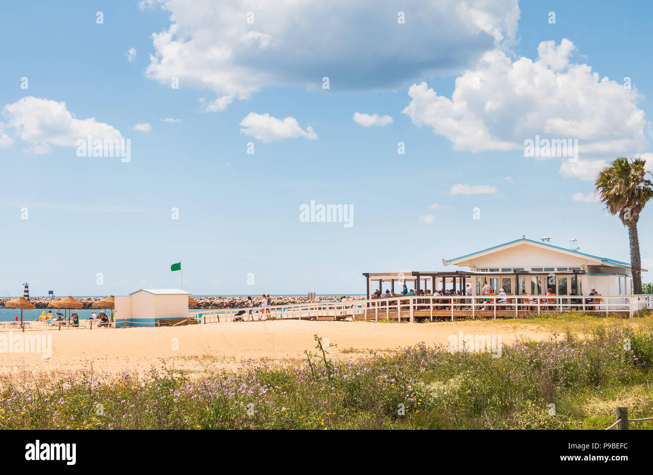 Vilamoura, Portugal - May 1, 2018: beach atmosphere on the terrace of a beach restaurant where customers have lunch on a spring day Stock Photo