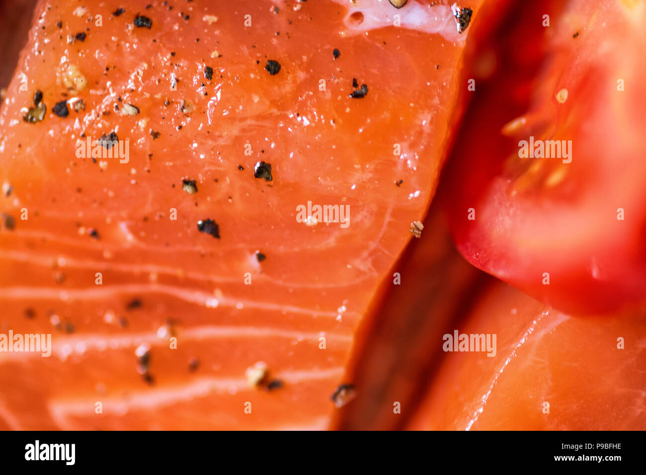 Closeup view fresh raw salmon fillets with herbs and spices on baking
