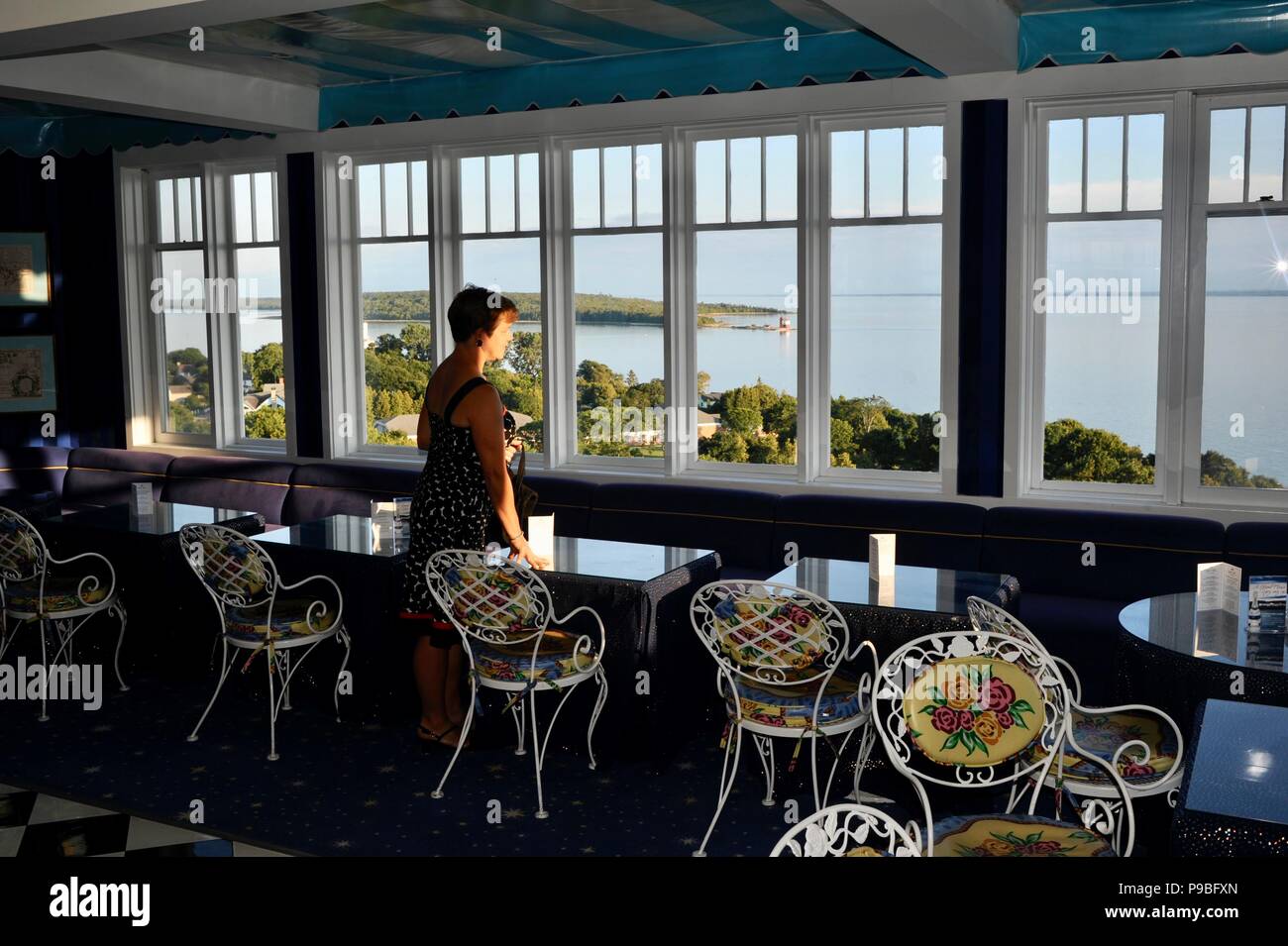 Woman looking out through windows over lake from cupola bar at Historic