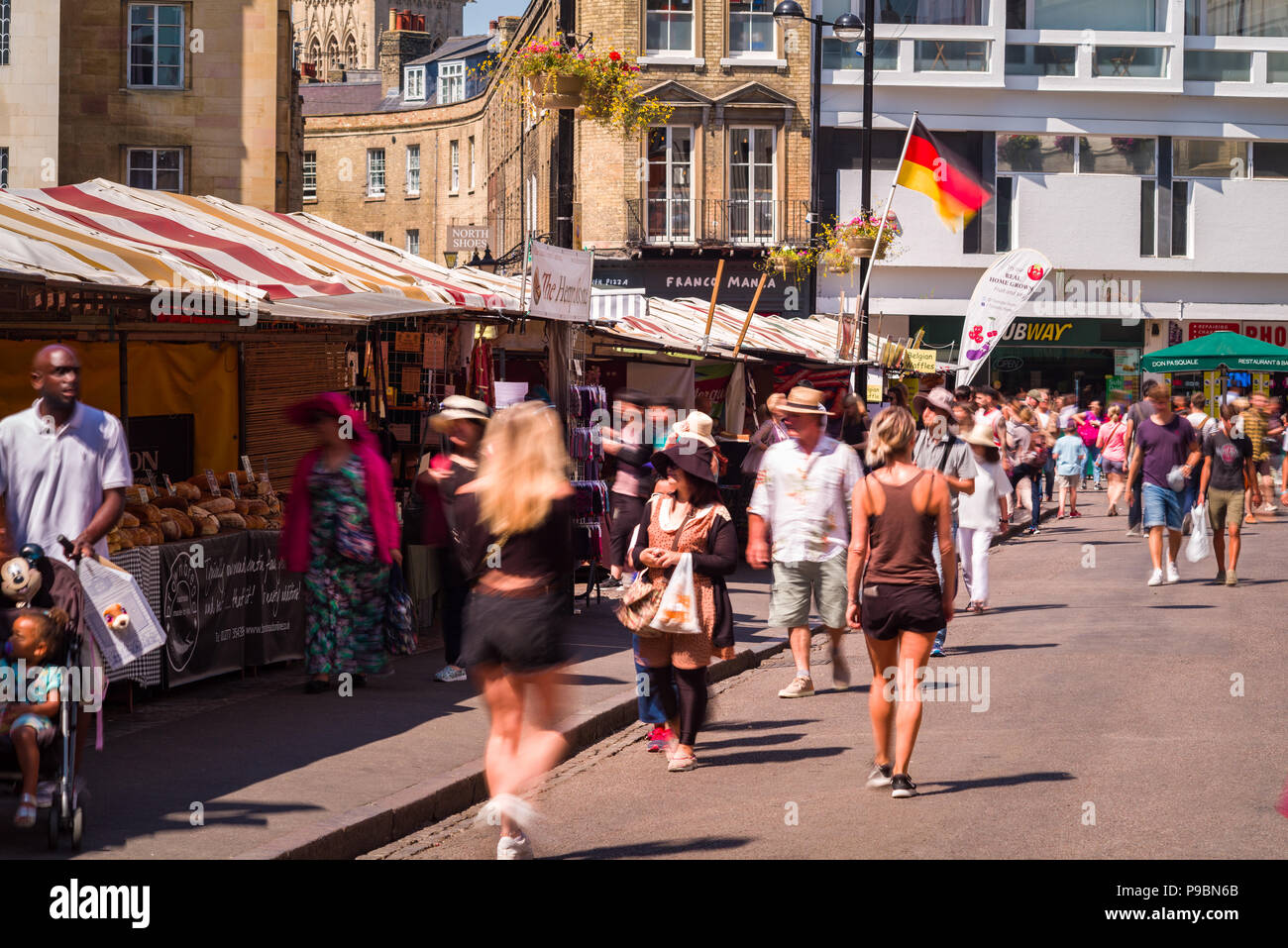 People browsing and walking past outdoor market stalls in Market street, Cambridge, UK Stock Photo