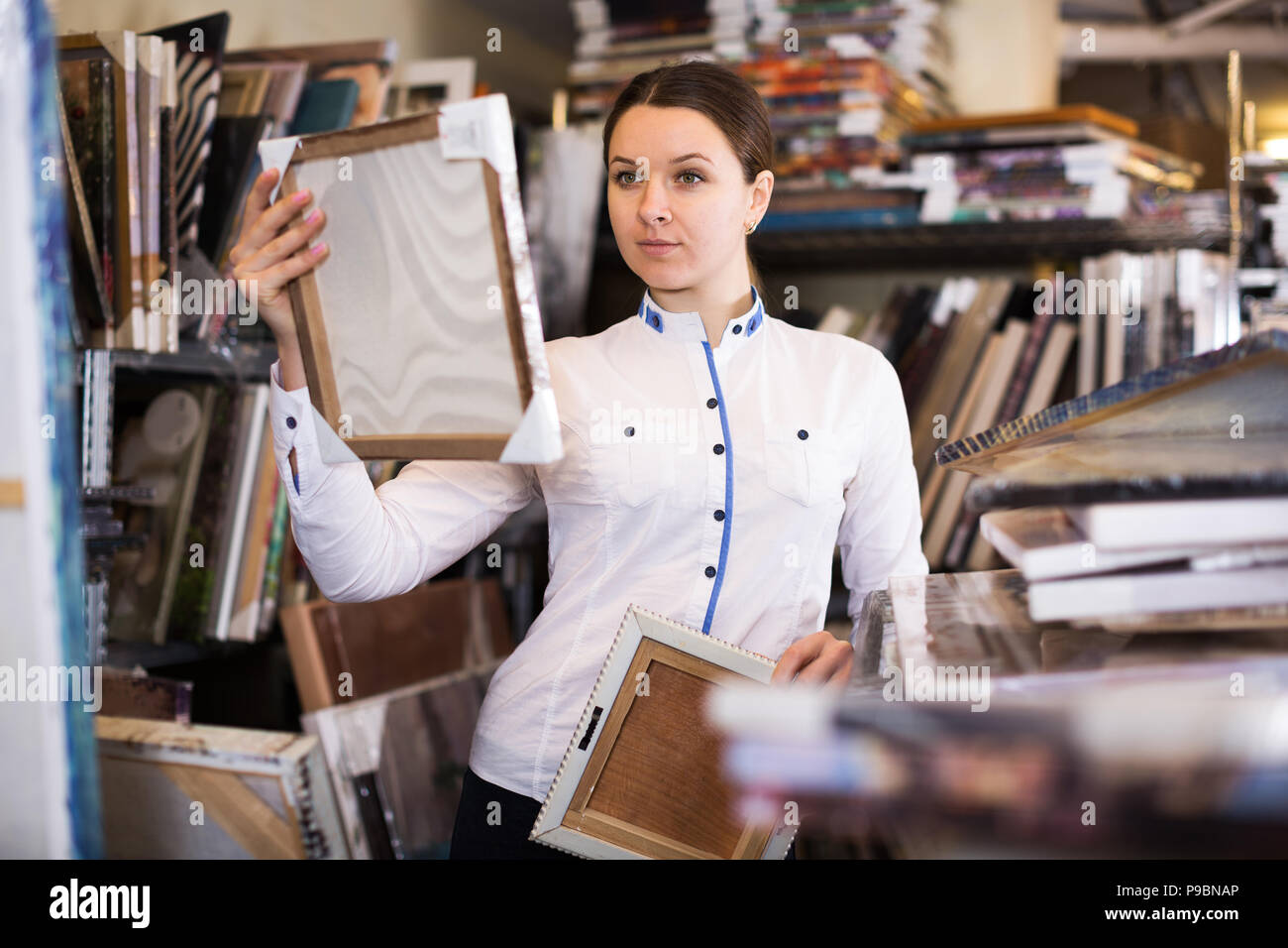 woman is buying pictures in the furniture store. Stock Photo