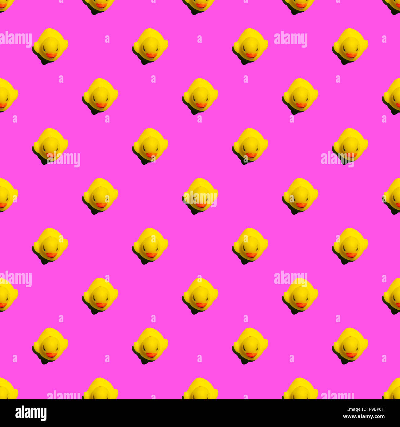 Small yellow rubber ducks on pink background seamless pattern; summer background Stock Photo