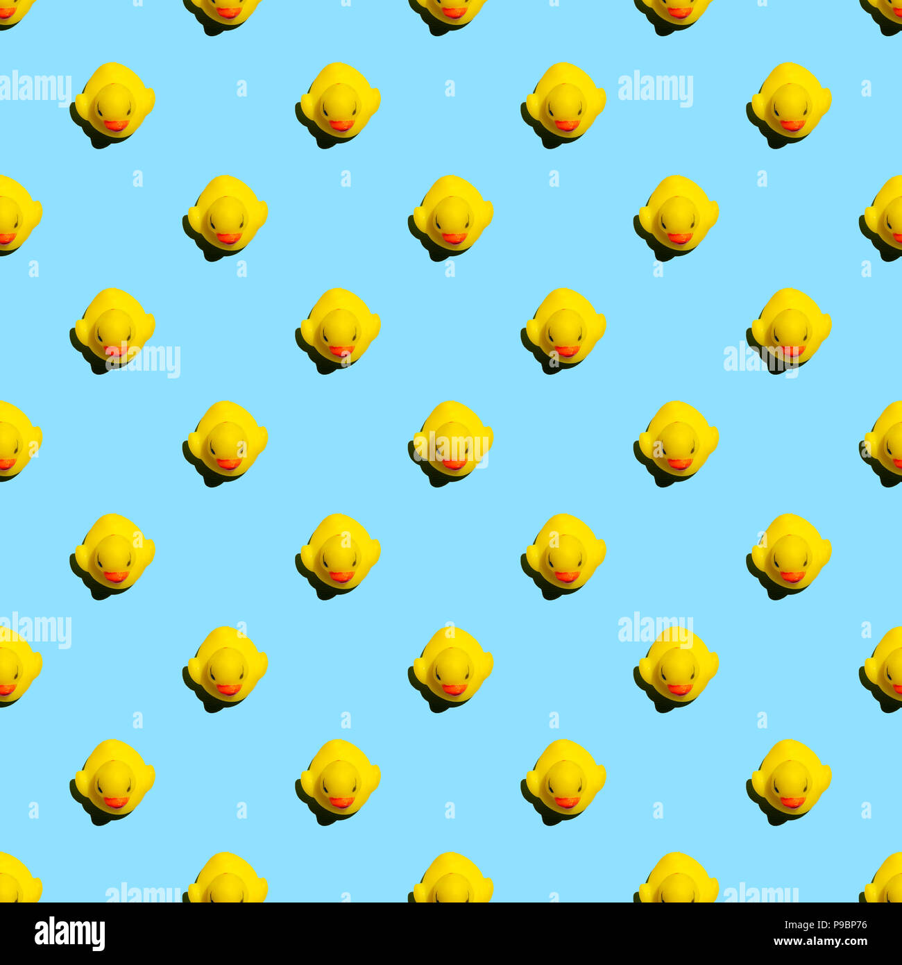 Small yellow rubber ducks on blue background seamless pattern; summer background Stock Photo