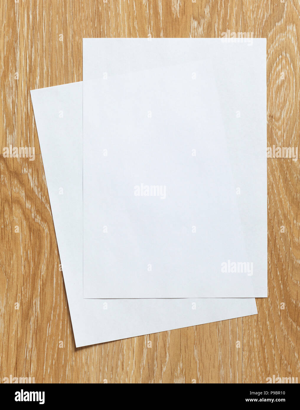 Two of blank sheets of paper portrait orientation  on wooden background Stock Photo