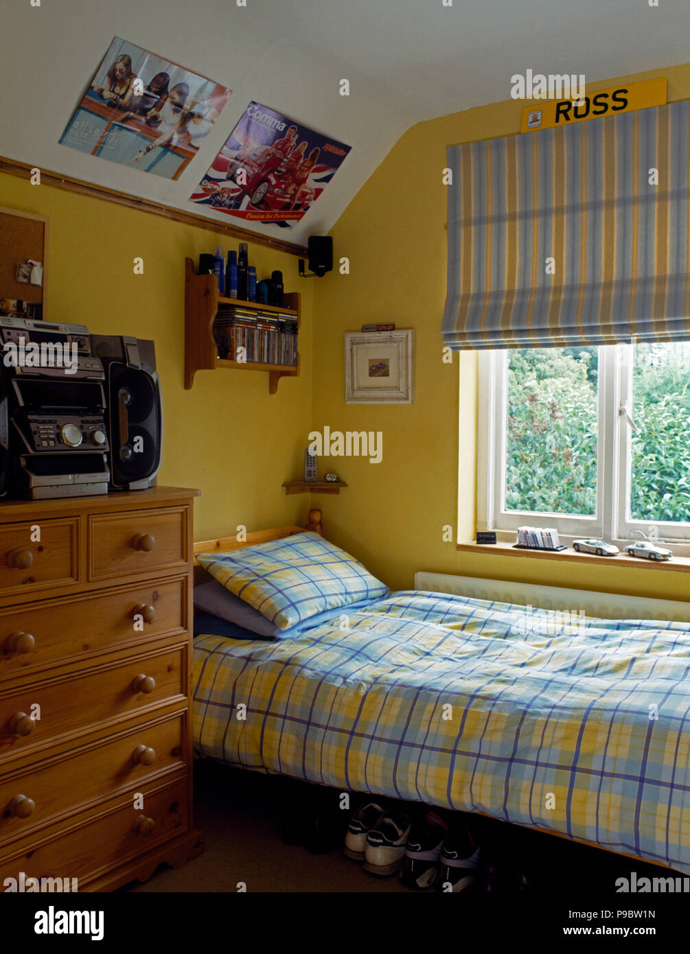 Yellow+blue striped blind above bed with matching checked duvet in teenager's yellow bedroom