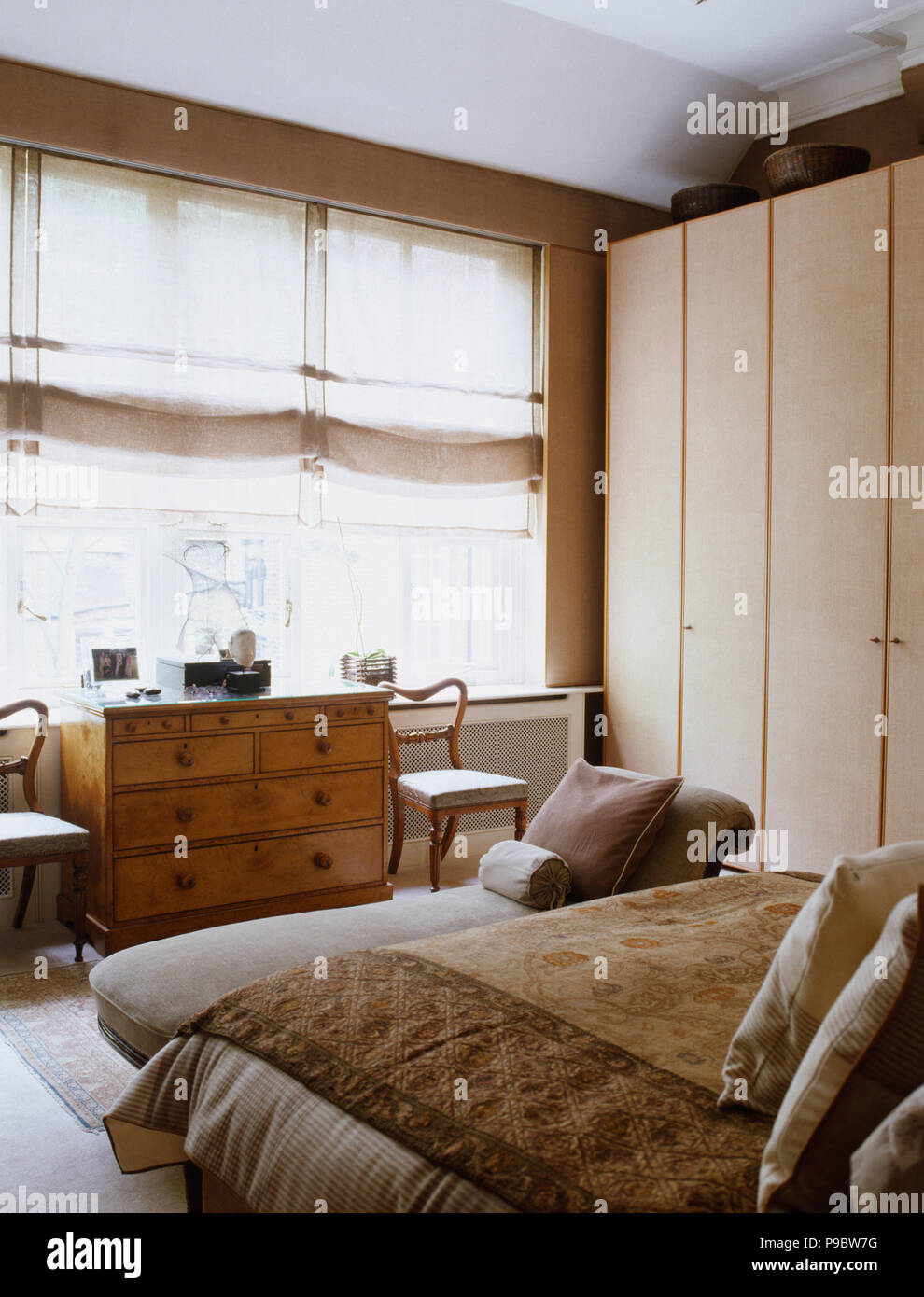 Beige Linen Blinds On Windows Above Antique Chest Of Drawers In