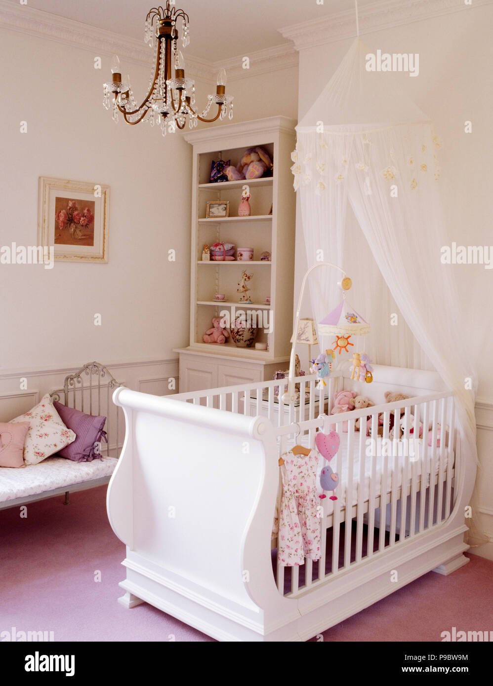 White drapes on white cot in nursery bedroom Stock Photo