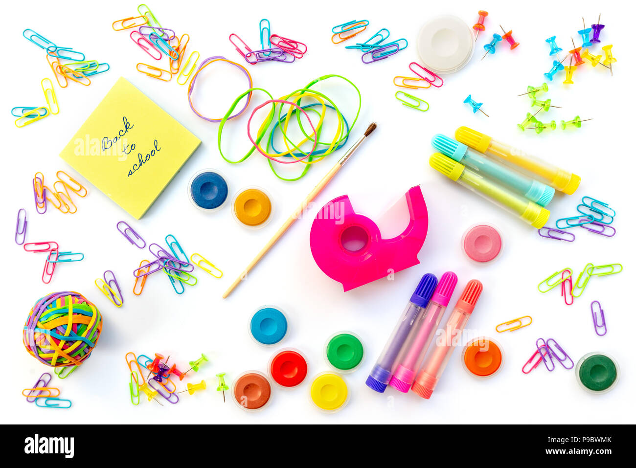 Back to shool written on sticky notes among  colorful school supplies  isolated on white background. Stock Photo