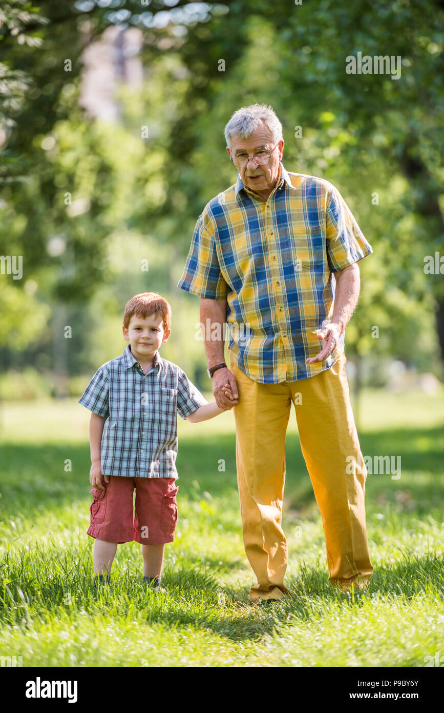 Grandfather and grandson talking in park Stock Photo - Alamy