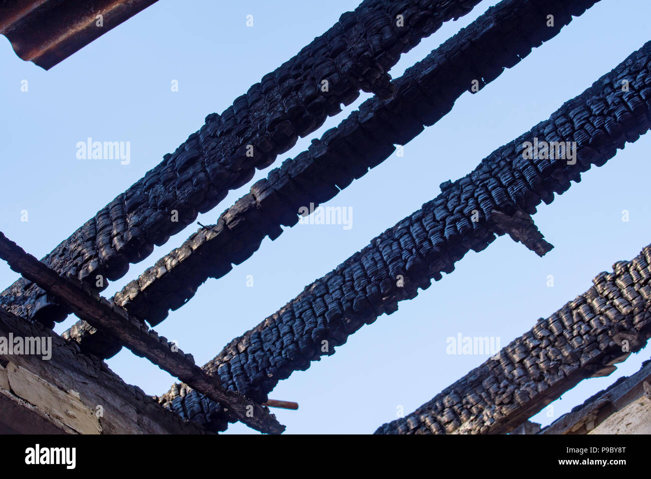 The charred timber beams of the burnt out roof of the old cottage at the Maltings in Mittagong NSW, Australia Stock Photo