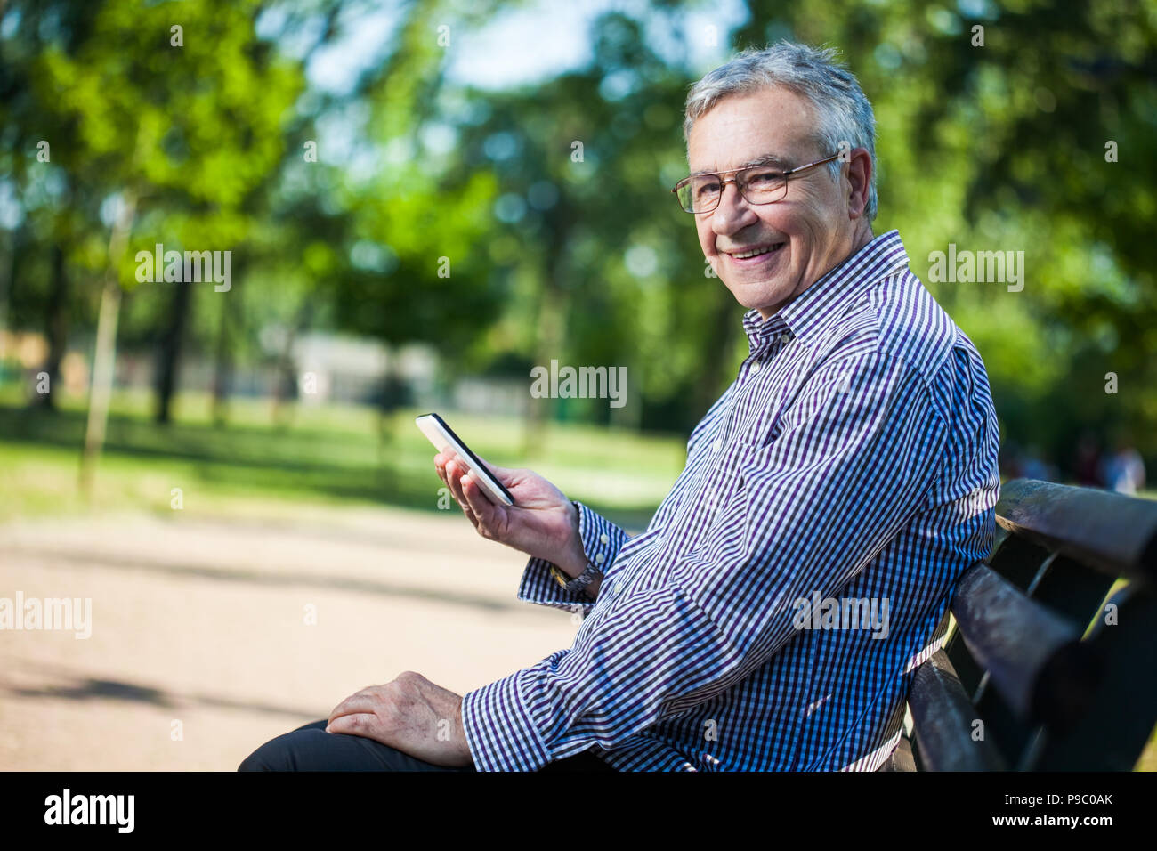 Senior man using digital tablet in park Stock Photo